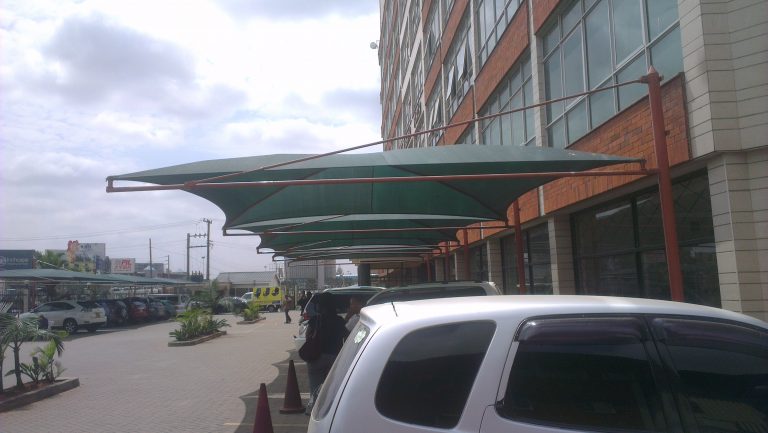 Curved cantilever car shade over cars at an office